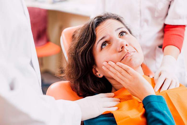 Pained woman with toothache visiting her Toronto emergency dentist