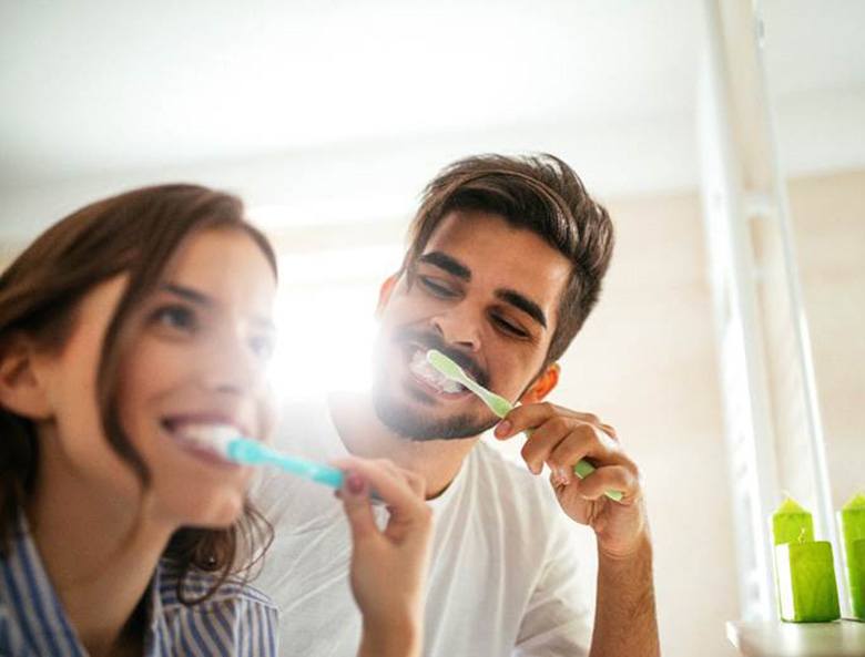 couple brushing teeth for dental implant care in Toronto