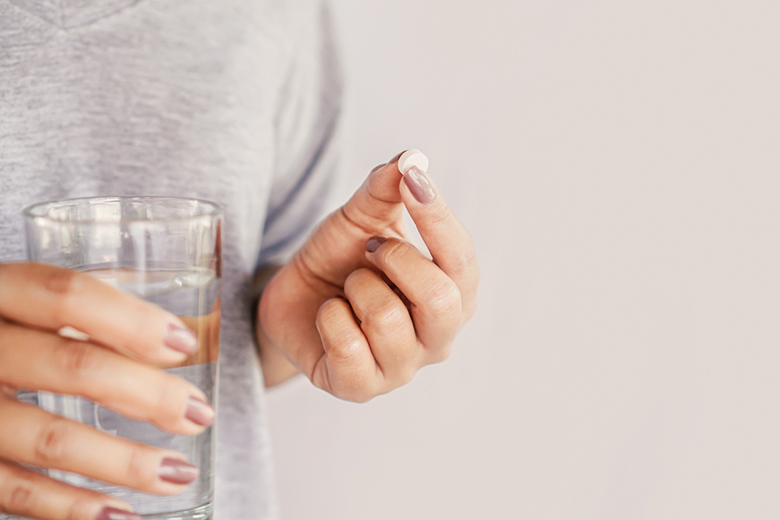 Woman taking a pill with water